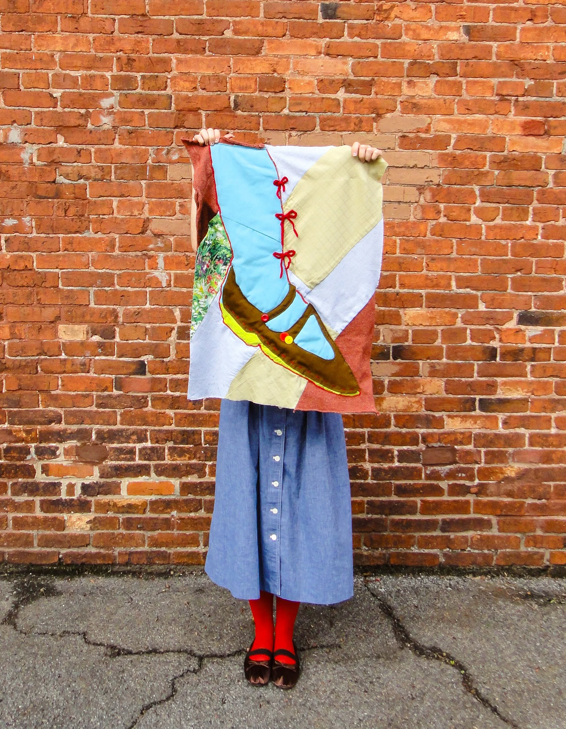 Blue Mary Jane, 2023.
Secondhand quilted cotton, patchwork knit "brick" panels, knit bows, and found buttons.
